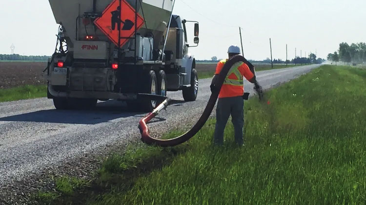 High-efficiency seeding of a roadside ditch with the use of a blower truck. Quality Turf.