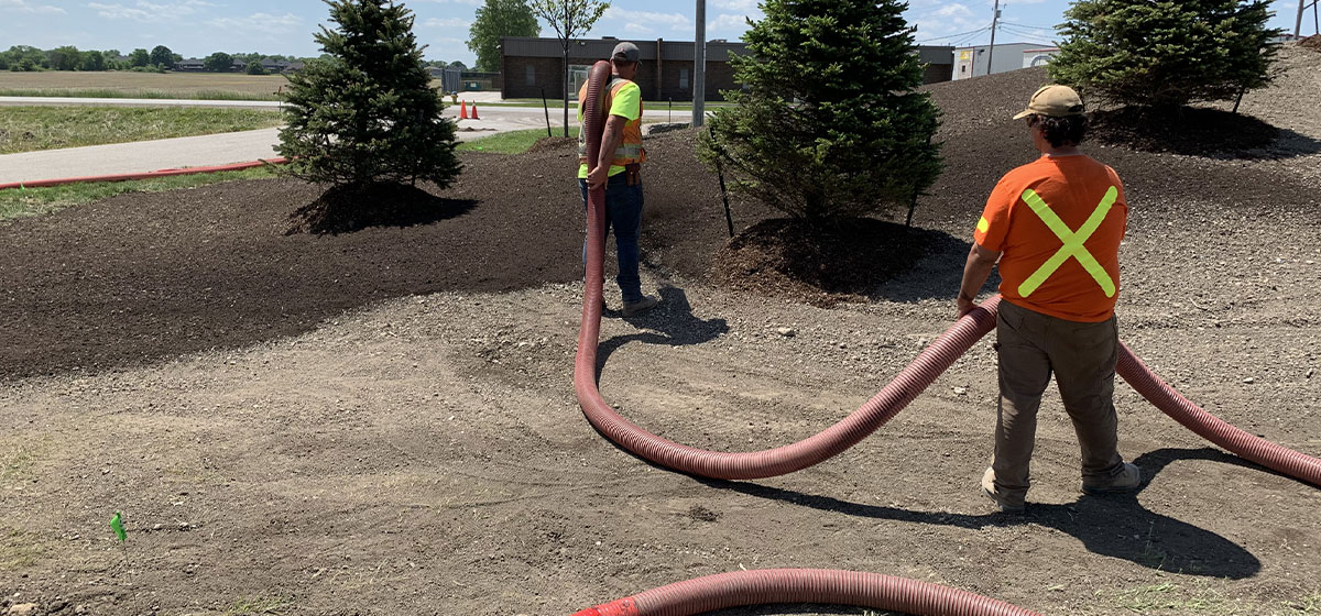 High-capacity blower truck applying topsoil to commercial landscape berms at LFX Supply center, on Manning Road, Tecumseh.