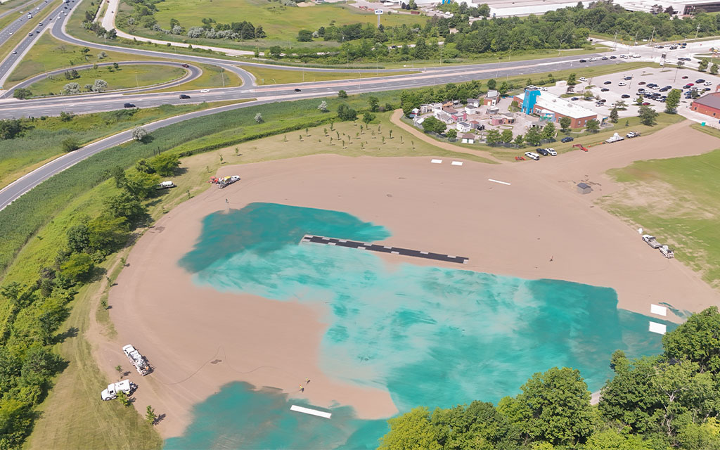 Aerial drone view of a large open acreage and ground restoration project undergoing professional hydroseeding coverage.